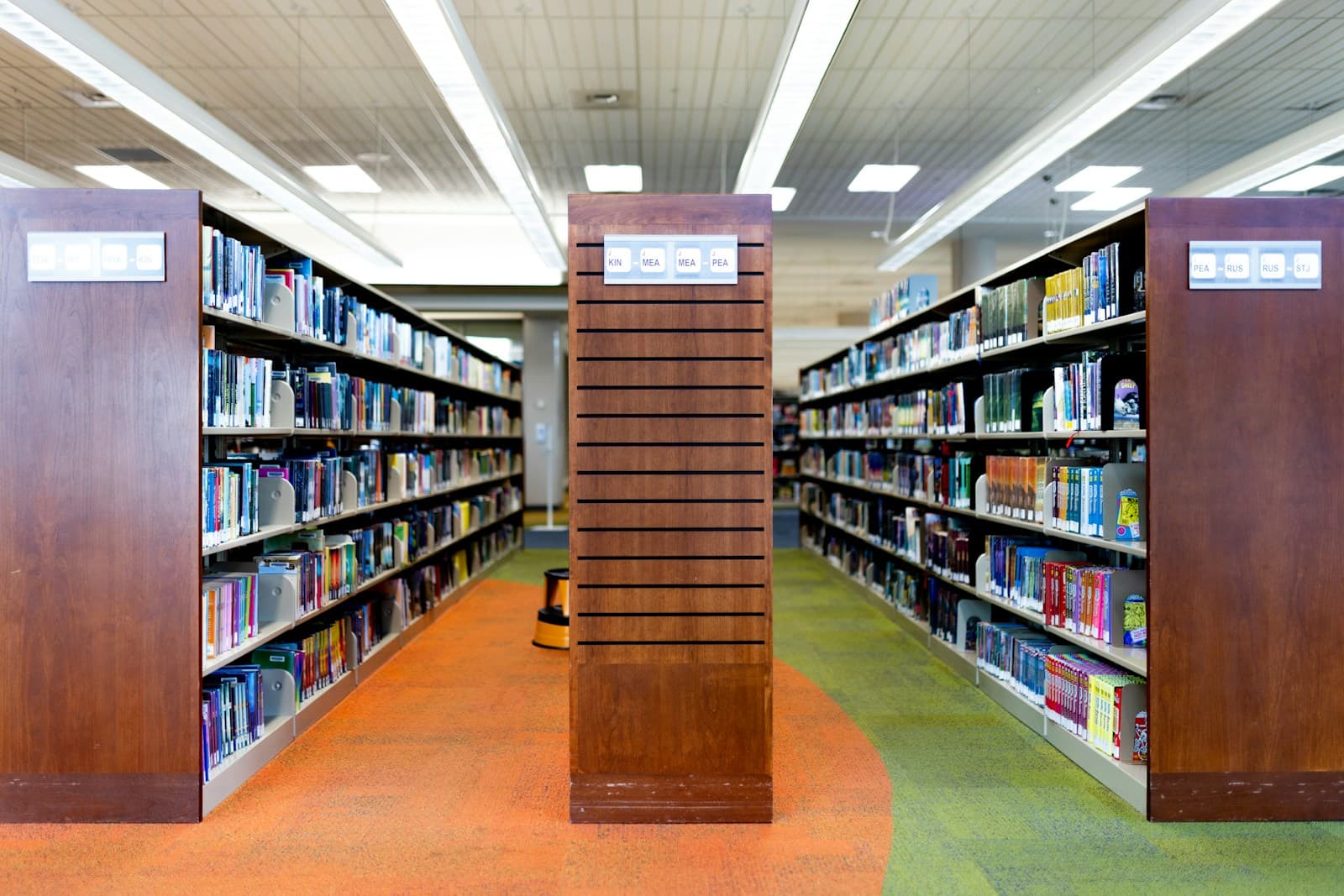 A row of bookshelves in a library filled with books